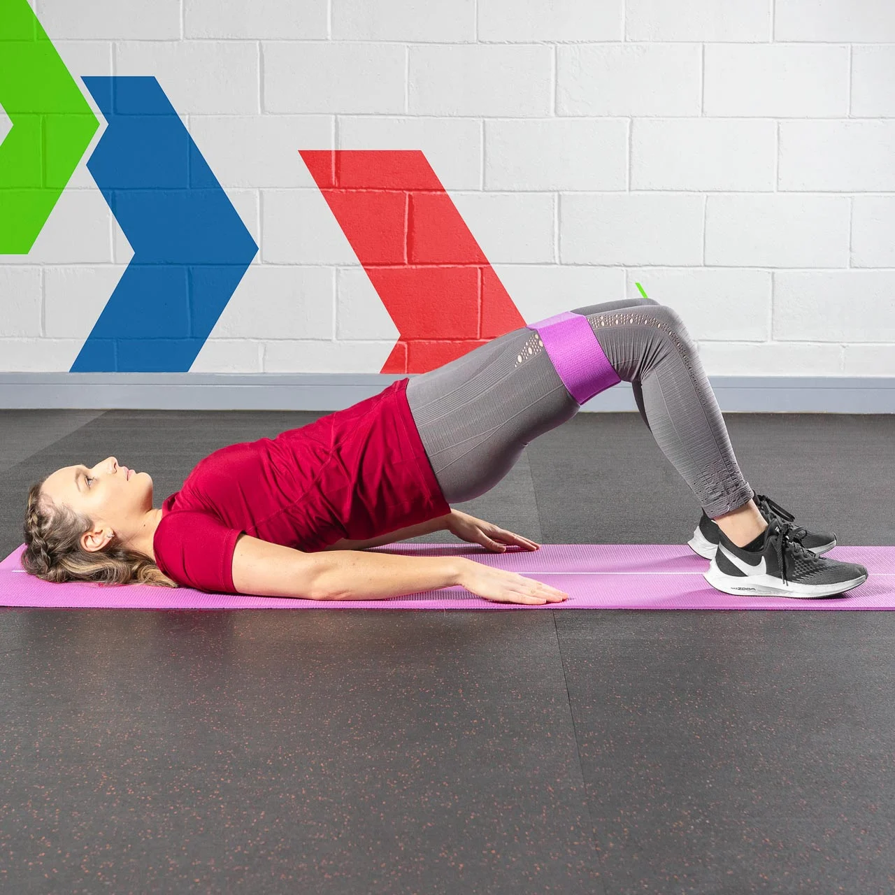 Participant following a printed session sheet beside resistance bands on a mat